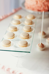 Glass plate with white macaroons stands on glasses