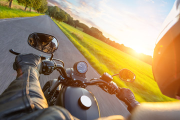 Driver riding motorcycle on an asphalt road