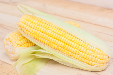 Fresh corn on wooden background.