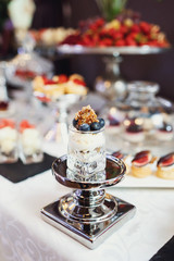 Blueberry dessert in a glass stands on steel dish