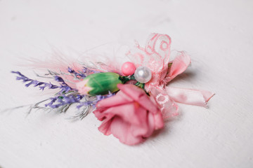 Look from above at boutonniere made of pink rose, lavander and p