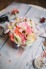 Bouquet with orchids and roses stands on wooden table of florist