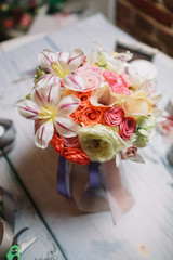 Blue ribbons hang from bouquet of orchids and roses
