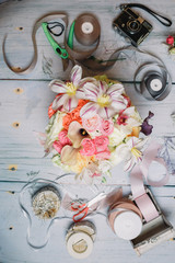 Rolls of ribbons surround wedding bouquet on table