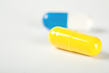 Two medical pills blue and red with shadows