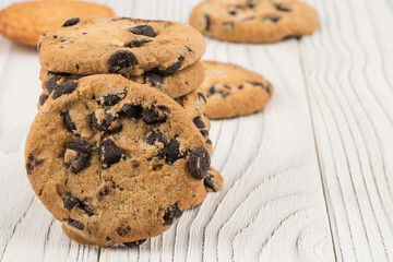 Chocolate cookies closeup on white old wooden table.