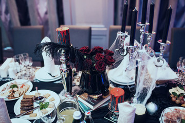 Dark red roses in black vase stand on heap of books