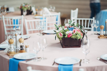 Dark wooden box with flowers stands in the centre of dinner tabl