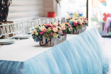 Wooden boxes with colorful roses stand on blue table