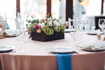 Dark wooden box with roses  and greenery stands in the middle of