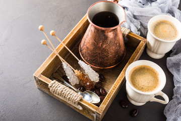 Cup of coffee and coffee pot in vintage wooden tray, copy space, top view.