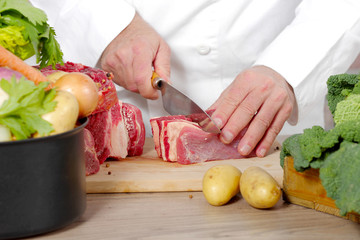 Chef cutting the meat on a wooden board