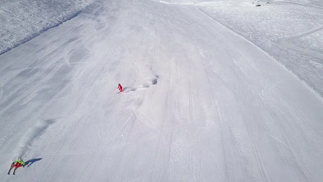 4k footage, drone aerial view two skiers skiing down empty ski slope
