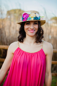 Stylish woman with a red dress and straw hat with flowers