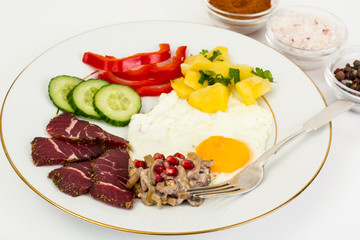 Fried egg with vegetables and a side dish of potatoes with mushr