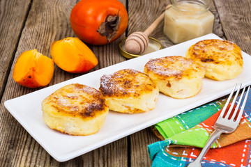 Cottage cheese pancakes with slices of persimmon for breakfast