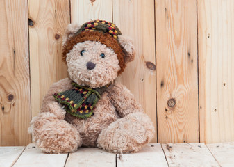 Teddy bear sit on wooden background.