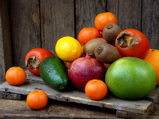 Composition of mix colored tropical and mediterranean fruits on wooden background. Concepts about decoration, healthy eating