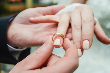 marriage hands with rings. birde wears the ring on the finger of the groom