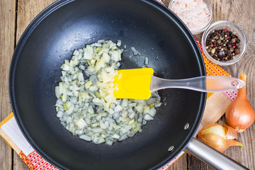Fried onion in oil in a frying pan