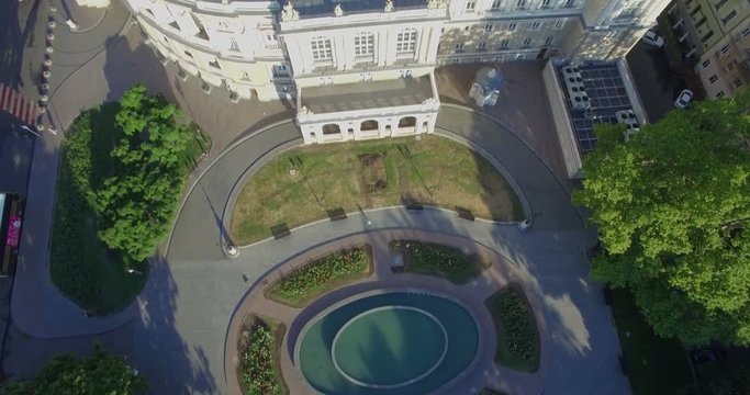 Aerial camera tilts from the pond to the side of the Odessa Opera House in Ukraine