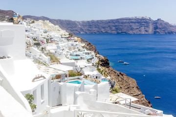 Fototapeta na wymiar Beautiful view with traditional white buildings over the village of Oia at the Island Santorini, Greece on the Mediterranean sea and rock background