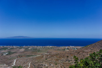 Fototapeta na wymiar Panoramic view of vineyards with blue mediterranean sea and volcano background on Santorini island, Greece. 