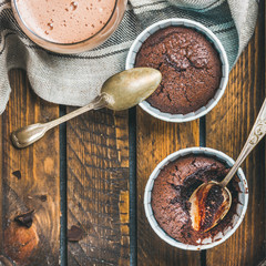 Chocolate souffle in individual baking cups and chocolate mocha coffee in wooden serving tray, top view, copy space, square crop © sonyakamoz