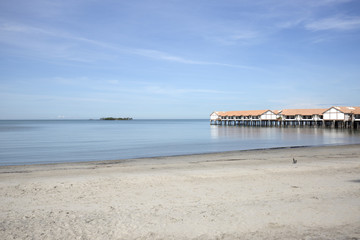 Beautiful day with blue sky and white sandy beach.