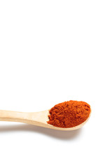 Chili powder in a wooden spoon isolated over white background