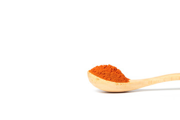 Chili powder in a wooden spoon isolated over white background
