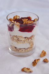 yogurt with muesli and jam on a white surface