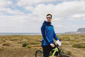 handsome man  in casual outfit ride a mountain bike on island