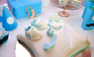 Closeup of cake on a children's holiday in the background. 
