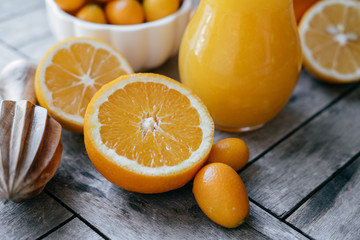 Fresh Kumquat in a white bowl, oranges, lemons and fresh juice s