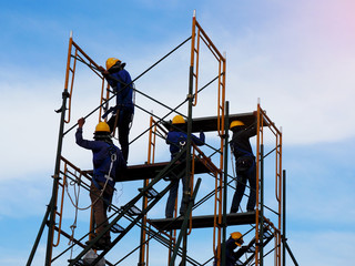 Construction workers working on scaffolding,Man Working on the Working at height with blue sky at construction site