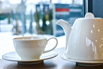 Cup of tea and teapot on a wood table in the restaurant