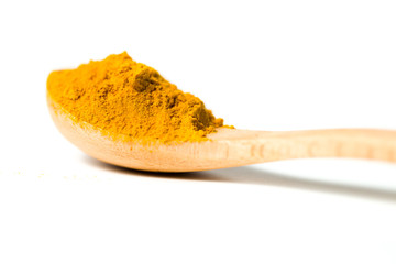 Turmeric powder in a wooden spoon isolated over white background