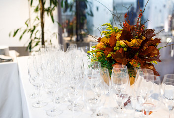 Beautiful stylish autumn bouquet and glasses on the table