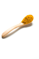 Turmeric powder in a wooden spoon isolated over white background