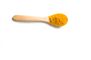 Turmeric powder in a wooden spoon isolated over white background