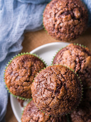 Chocolate banana muffins with sugar topping on dark blue background. Home made single portion snack. Winter baked dessert
