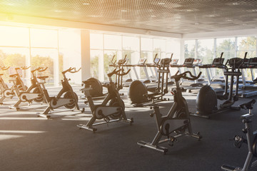 Modern gym interior with equipment, fitness exercise bikes