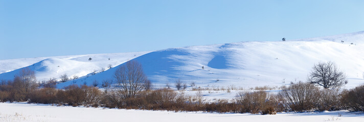 Fototapeta na wymiar Panoramic view of snow-covered hills in central Russia. Winter s