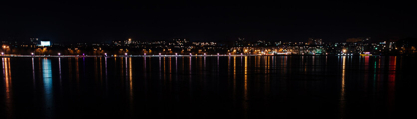 Panorama of night city lights and reflections on lake at Ternopi