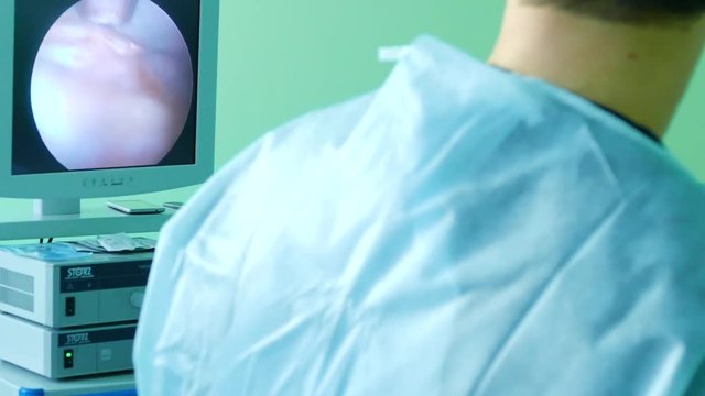 Doctor looking in endoscope monitor during surgery
