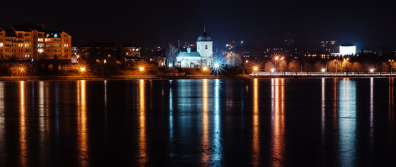 Panorama of night city lights and reflections on lake at Ternopi