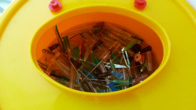 container with needles from syringes for processing