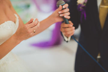 bride holding ring during wedding ceremony,  and groom on  