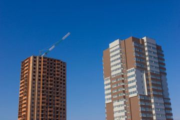 Fototapeta premium Crane and building construction site against blue sky